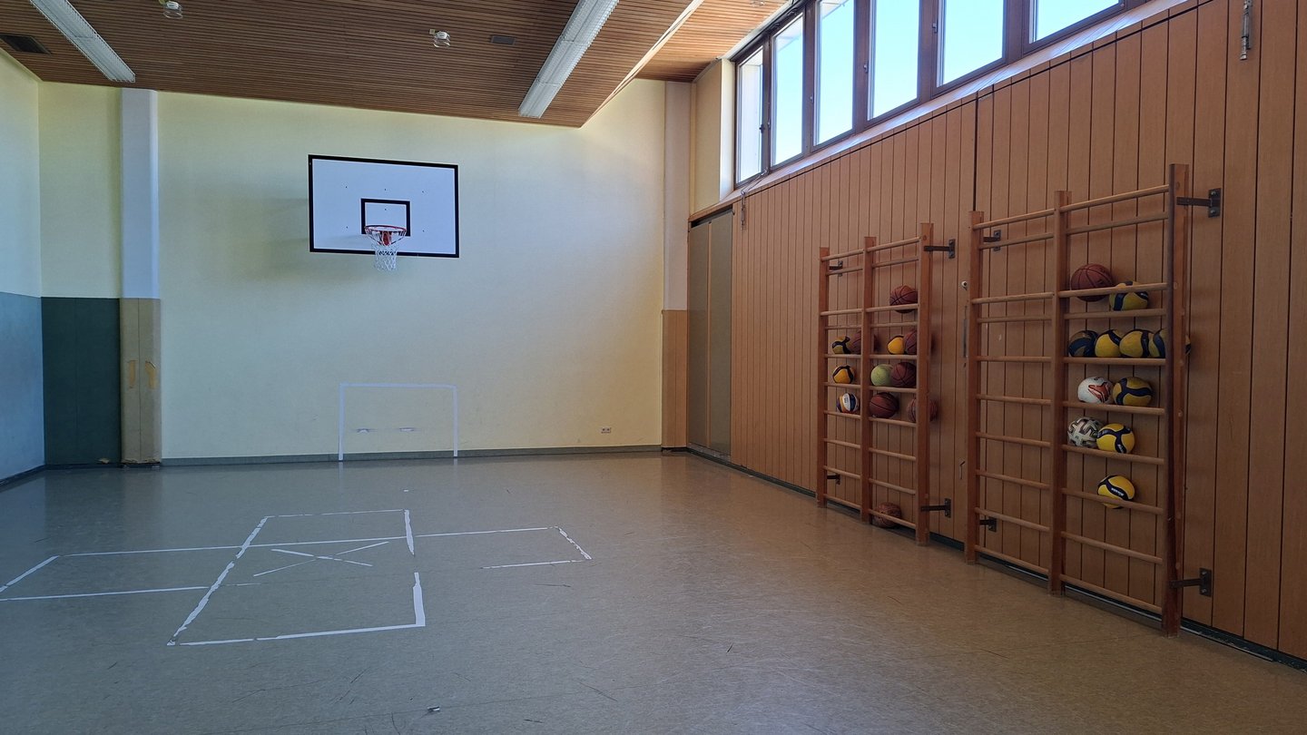Turnhalle mit Basketballkorb, Klettergerüst und Bällen