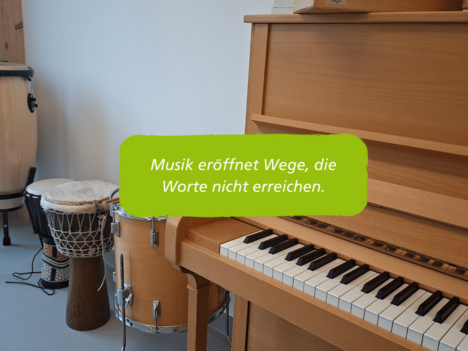 Trommeln und ein Klavier mit dem Schriftzug: Musik eröffnet Wege, die Worte nicht erreichen.