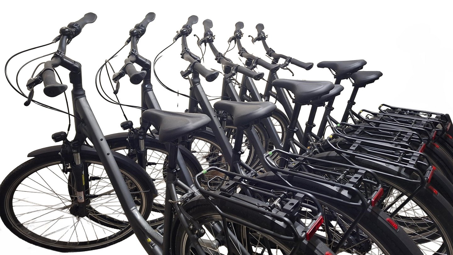 Sechs nebeneinander stehende schwarze Fahrräder