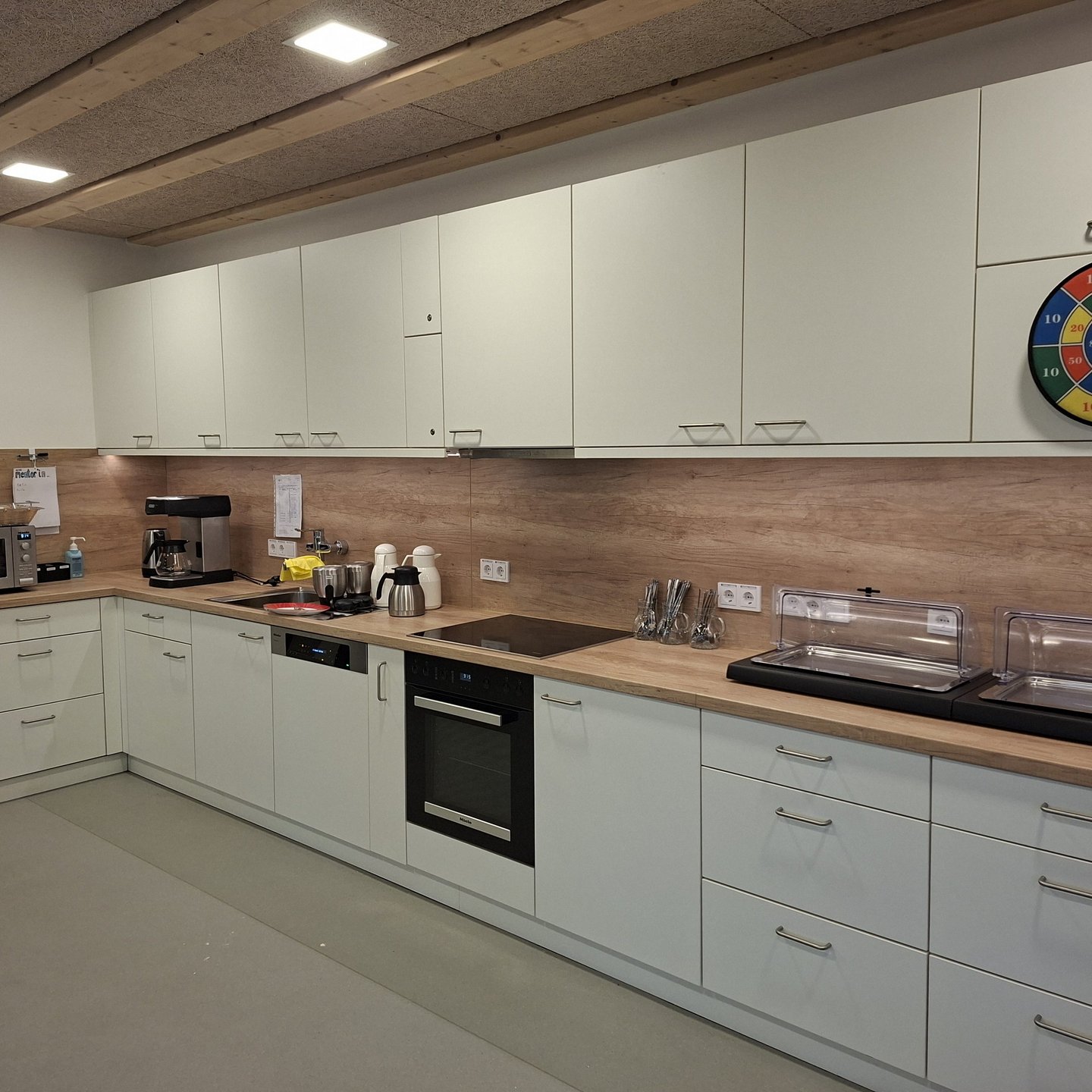 Küchenzeile in L-Form mit Herd, Ofen, Spüle, Geschirrspüler und Kaffeemaschine