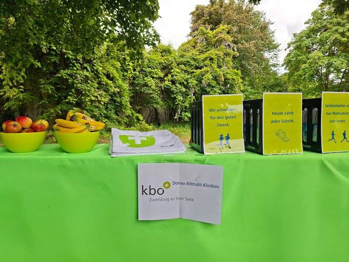 Stand mit Obst, Stofftaschen und Motivationssprüchen mit dem kbo-DAK-Logo im Vordergrund