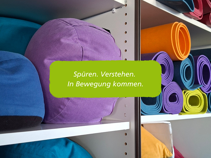 Yogamatten und Sitzkissen. Schriftzug: Spüren. Verstehen. In Bewegung kommen.